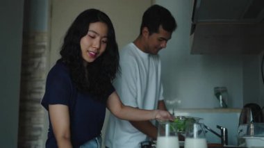 Mutlu çift modern mutfaklarında taze malzemeler hazırlıyor - 4K Yatay