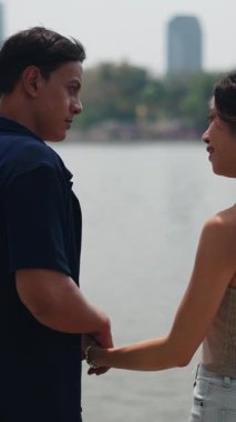 Gölün kenarında el ele tutuşup özel bir anı paylaşan romantik bir çift.