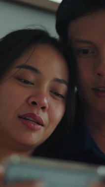 Mutlu çift, akıllı telefondan bir şey izlerken bir anlık yakınlık paylaşıyor.