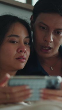 Akıllı telefona bakan Güneydoğu Asyalı çift, samimiyet ve bağlantı anlarını paylaşıyor