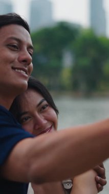 Sevgi dolu bir çift, uzak göl manzarasını, ortak bir heyecanla gösterir.