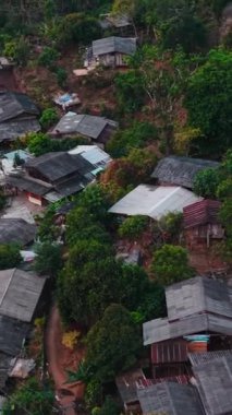 Tropikal bitki örtüsünün arasına yerleşmiş geleneksel evler sakin bir köy manzarası yaratıyor.