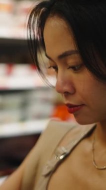 Müşteri önceden paketlenmiş yemekleri süpermarketin soğutmalı koridorunda seçiyor