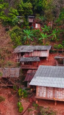 Ahşap evler bir yamaçtaki köyü süslüyor, yemyeşil bir manzaranın ortasında geleneksel mimariyi sergiliyor.