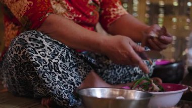Close-up Southeast Asian woman peeling and crushing ingredients to mix them to make a traditional meal - 4K Horizontal