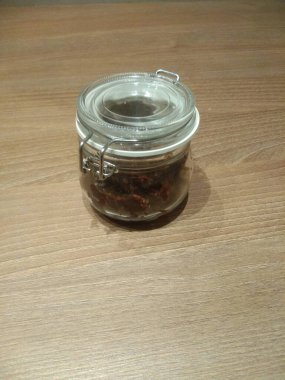 Ahşap bir masada bir kavanoz reçel.