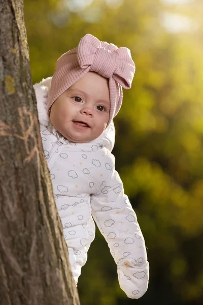 Child White Jumpsuit Peeks Out Tree Background Autumn Nature Girl — Stock Photo, Image