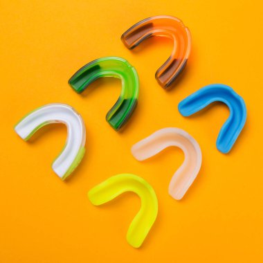 Sarı arka planda altı renkli boks kalkanı var.