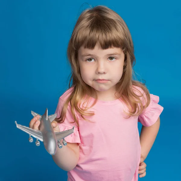 少女は飛行機を手にして悲しみ 旅の夢 コンセプト 青い背景で — ストック写真