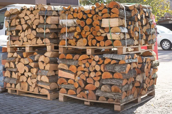 stock image Firewood stacked on four pallets, pallets stacked one on top of the other, outdoors