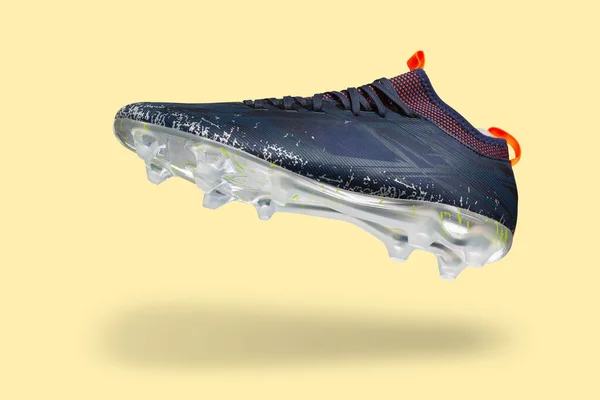 Football shoes levitate, on a yellow background, casting a shadow, concept, copy space