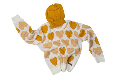 Knitted sweater and hat, as if levitating, with a pattern of mustard-colored hearts, on a white background, isolate
