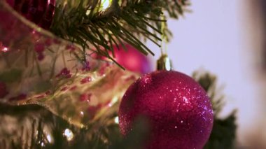 Kırmızı top ve altın kurdele yanıp sönen ışıklarla Noel ağacında süslenir.