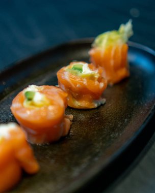 Siyah tabaklı siyah bir masada nefis bir gurme suşi.