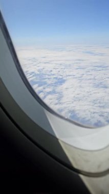 Gökyüzü bulutlu. Bir uçak penceresinden ticari bir uçuş..