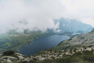 Kanada Rocky Dağları 'nda yüksek dağ göllerinin arka planında sis olan dramatik manzaralar.