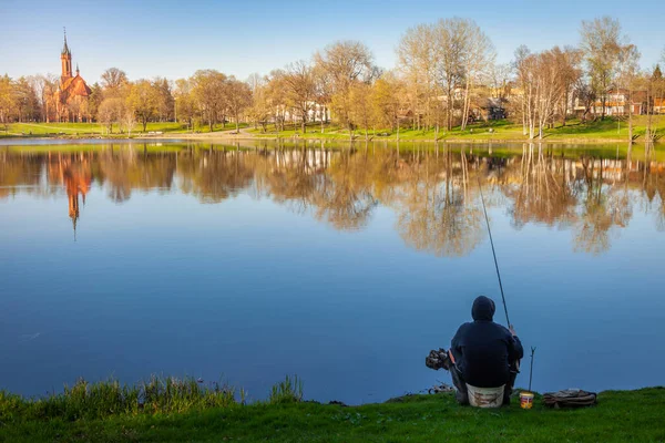 Huzurlu şehir parkı ve göl kenarındaki kilise güneş doğarken, Litvanya