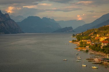 Malcesine 'deki huzurlu Garda Gölü' nün üzerinde dramatik bir günbatımında, İtalyan Alpleri, uzun pozlama