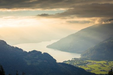 İsviçre Alpleri ve Thun Gölü 'nün dramatik günbatımındaki hava manzarası, Interlaken, İsviçre