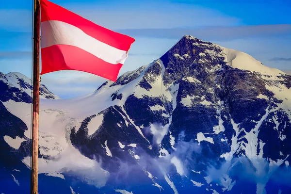 Austrian flag in Grossglockner National Park, snowcapped alps at dramatic sky, Austria