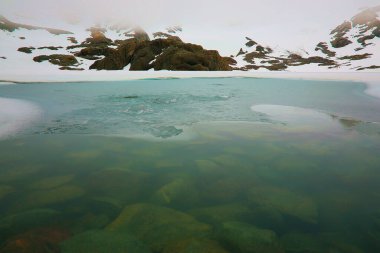 Melting frozen and peaceful lake, Andes landscape in Tierra Del fuego, Ushuaia, Argentina, South America