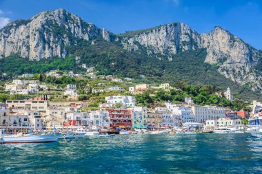 Idyllic Capri island city cliffs and marina with boats and yacht, amalfi coast, Italy