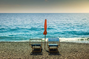 Positano secuded beach with chairs and parasol sunshade at sunny day, amalfi coast, Italy