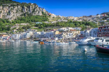 Idyllic Capri island city cliffs and marina with boats and yacht, amalfi coast, Italy
