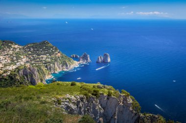 Idyllic aerial view of Capri island city and Faraglioni cliffs and marina with boats and yacht, amalfi coast, Italy