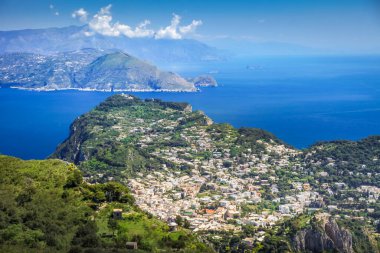 Idyllic aerial view of Capri island city and Faraglioni cliffs and marina with boats and yacht, amalfi coast, Italy