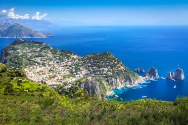 Idyllic aerial view of Capri island city and Faraglioni cliffs and marina with boats and yacht, amalfi coast, Italy