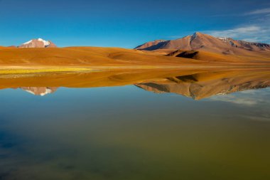 Salt lake Lejia reflection and idyllic volcanic landscape at Sunset, Atacama desert, Chile