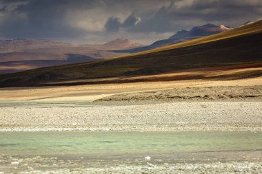 Salt lake reflection and idyllic volcanic landscape at Sunset, Atacama desert, Chile border with Bolivia