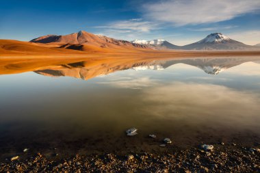 Salt lake Lejia reflection and idyllic volcanic landscape at Sunset, Atacama desert, Chile