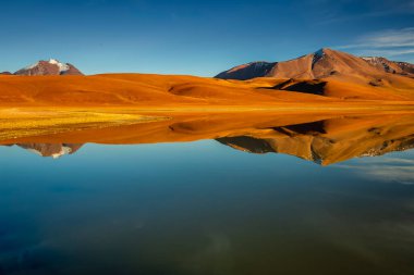 Salt lake Lejia reflection and idyllic volcanic landscape at Sunset, Atacama desert, Chile