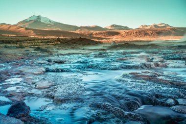 Geysers El Tatio with river and Peaceful dramatic volcanic landscape at sunrise, Atacama Desert, Chile clipart