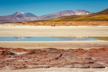 Salt lake reflection and idyllic volcanic landscape at sunrise, Atacama desert, Chile border with Bolivia