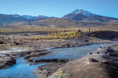 Geysers El Tatio with river and Peaceful dramatic volcanic landscape at sunrise, Atacama Desert, Chile