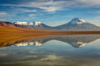 Salt lake Lejia reflection and idyllic volcanic landscape at Sunset, Atacama desert, Chile