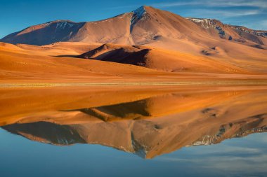 Salt lake Lejia reflection and idyllic volcanic landscape at Sunset, Atacama desert, Chile