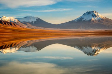 Salt lake Lejia reflection and idyllic volcanic landscape at Sunset, Atacama desert, Chile