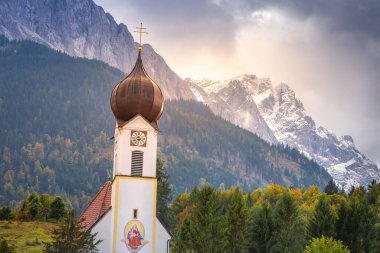 Grainau Church at golden autumn sunrise and Zugspitze massif, Bavarian alps , Germany