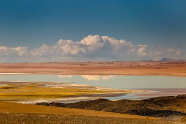 Salt lake reflection and idyllic volcanic landscape at Sunset, Atacama desert, Chile border with Bolivia