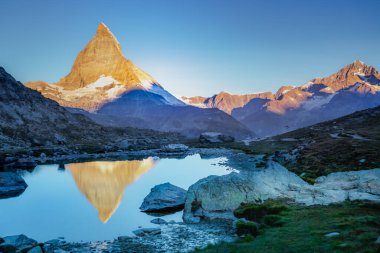 Reflection of the Matterhorn on blue and placid lake at sunrise, Swiss Alps, Zermatt, Switzerland