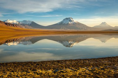 Salt lake Lejia reflection and idyllic volcanic landscape at Sunset, Atacama desert, Chile