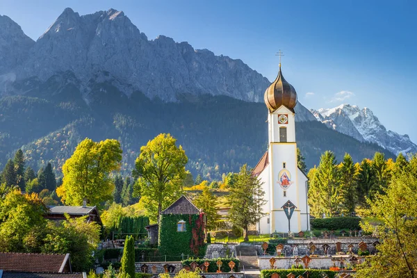Grainau Church at golden autumn sunrise and Zugspitze massif, Bavarian alps , Germany