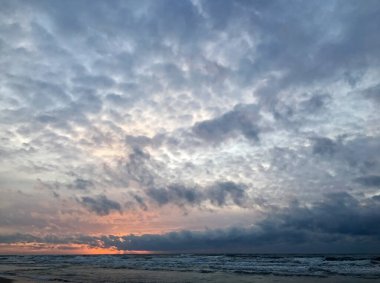 Baltık Denizi üzerinde dramatik bir gökyüzü. Litvanya, Nida yakınlarındaki Curonian Tükürüğünde Günbatımı.