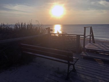 Gün batımında Curonian Spit 'in tepelerinde teras var. Litvanya 'nın Nida tatil köyünün sahiline tahta merdivenler..