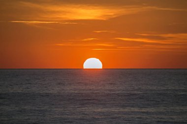 Denizin üzerinde yumuşak turuncu gün batımı. Metin ve başlıklar için uygun stil arkaplanı.