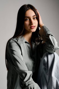 Bir fotoğraf stüdyosunda poz veren kazaklı ve eşofmanlı güzel bir kız.